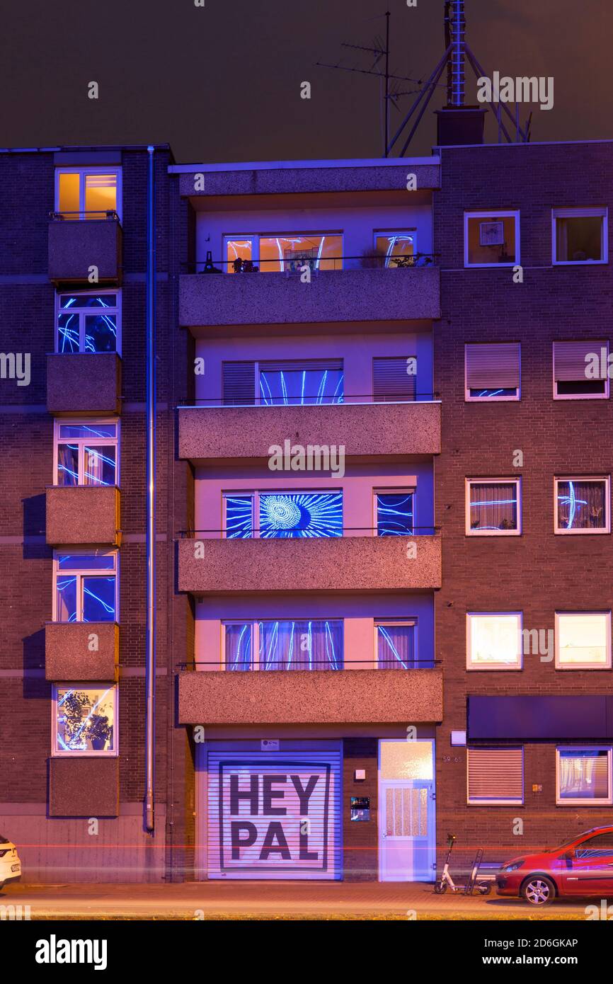 L'éclairage d'une roue ferris dans le port de Rheinau se reflète dans les fenêtres d'un immeuble d'appartements en face, Cologne, Allemagne. Die Beleuchtung ein Banque D'Images