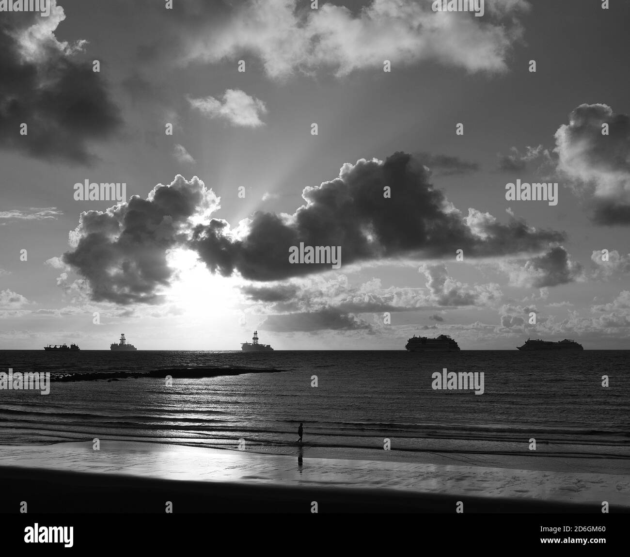 Plage à marée basse au lever du soleil, ciel avec nuages et navires dans la baie Banque D'Images