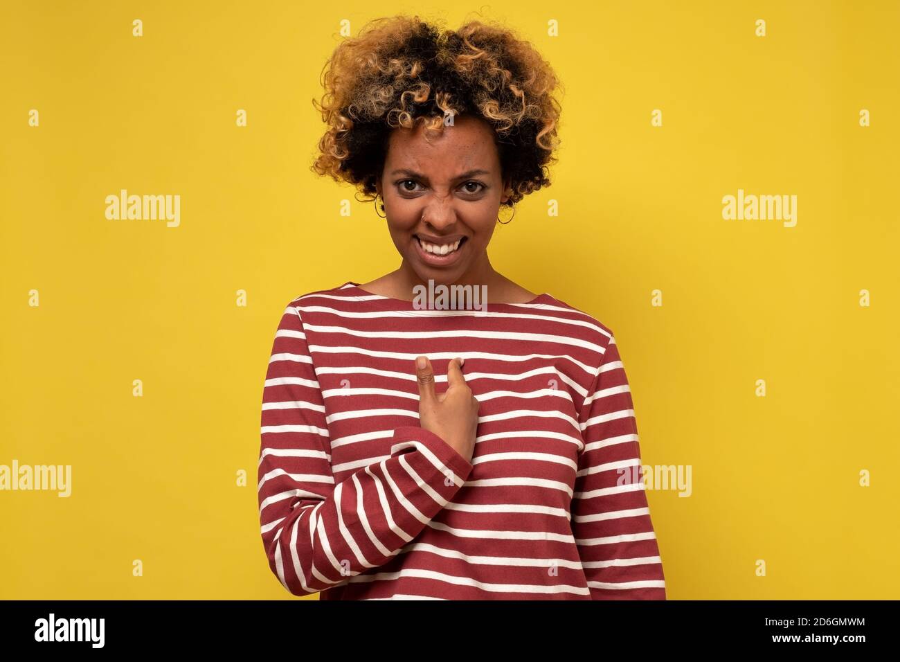 Interrogée et choquée, la femme africaine se fait remarquer en tenant le doigt sur la poitrine comme étant accusée. Banque D'Images