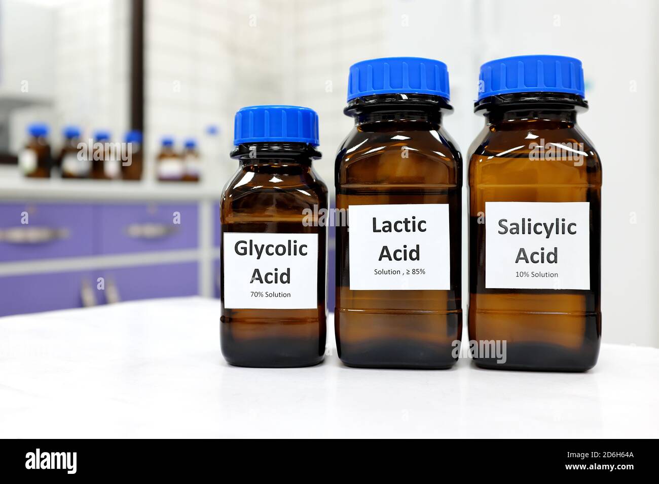 Concentration sélective de la solution liquide d'acide salicylique, lactique et glycolique dans un flacon en verre brun foncé sur fond de laboratoire de chimie blanche. Pelage chimique pour la recherche en soins de la peau. Banque D'Images