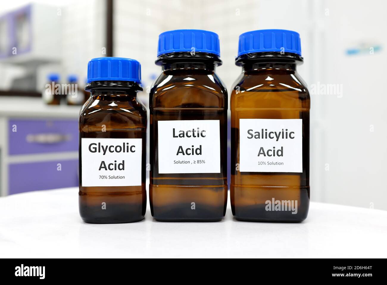 Concentration sélective de la solution liquide d'acide salicylique, lactique et glycolique dans un flacon en verre brun foncé sur fond de laboratoire de chimie blanche. Pelage chimique pour la recherche en soins de la peau. Banque D'Images