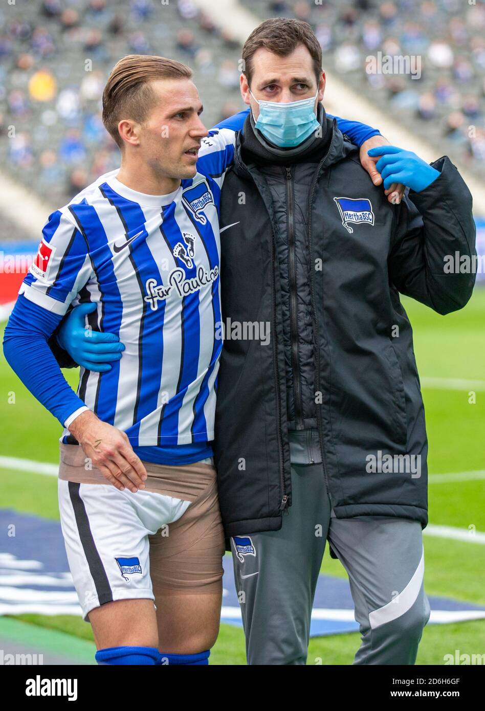 Berlin, Allemagne. 17 octobre 2020. Football: Bundesliga, Hertha BSC - VfB Stuttgart, 4ème jour de match, Stade Olympique. Peter Pekarik (l) de Berlin est soutenu par le physiothérapeute Michael Becker après une blessure à sa cuisse gauche. Crédit : Andreas Gora/dpa - REMARQUE IMPORTANTE : Conformément aux règlements de la DFL Deutsche Fußball Liga et de la DFB Deutscher Fußball-Bund, il est interdit d'exploiter ou d'exploiter dans le stade et/ou à partir du jeu pris des photos sous forme d'images de séquences et/ou de séries de photos de type vidéo./dpa/Alay Live News Banque D'Images