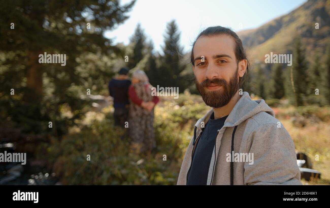 Village gens hors de foyer, ville ou village jeune hippie homme dans la nature regardant vers l'appareil photo et souriant Banque D'Images