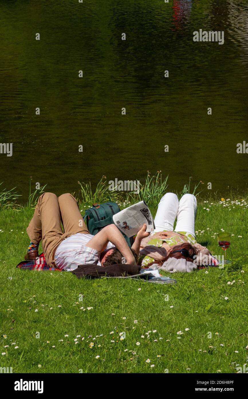 Un couple appréciant le soleil du début de l'été sur le bord du lac à la propriété du National Trust à Stourhead près de Mere dans Somerset. 26 mai 2013. P Banque D'Images