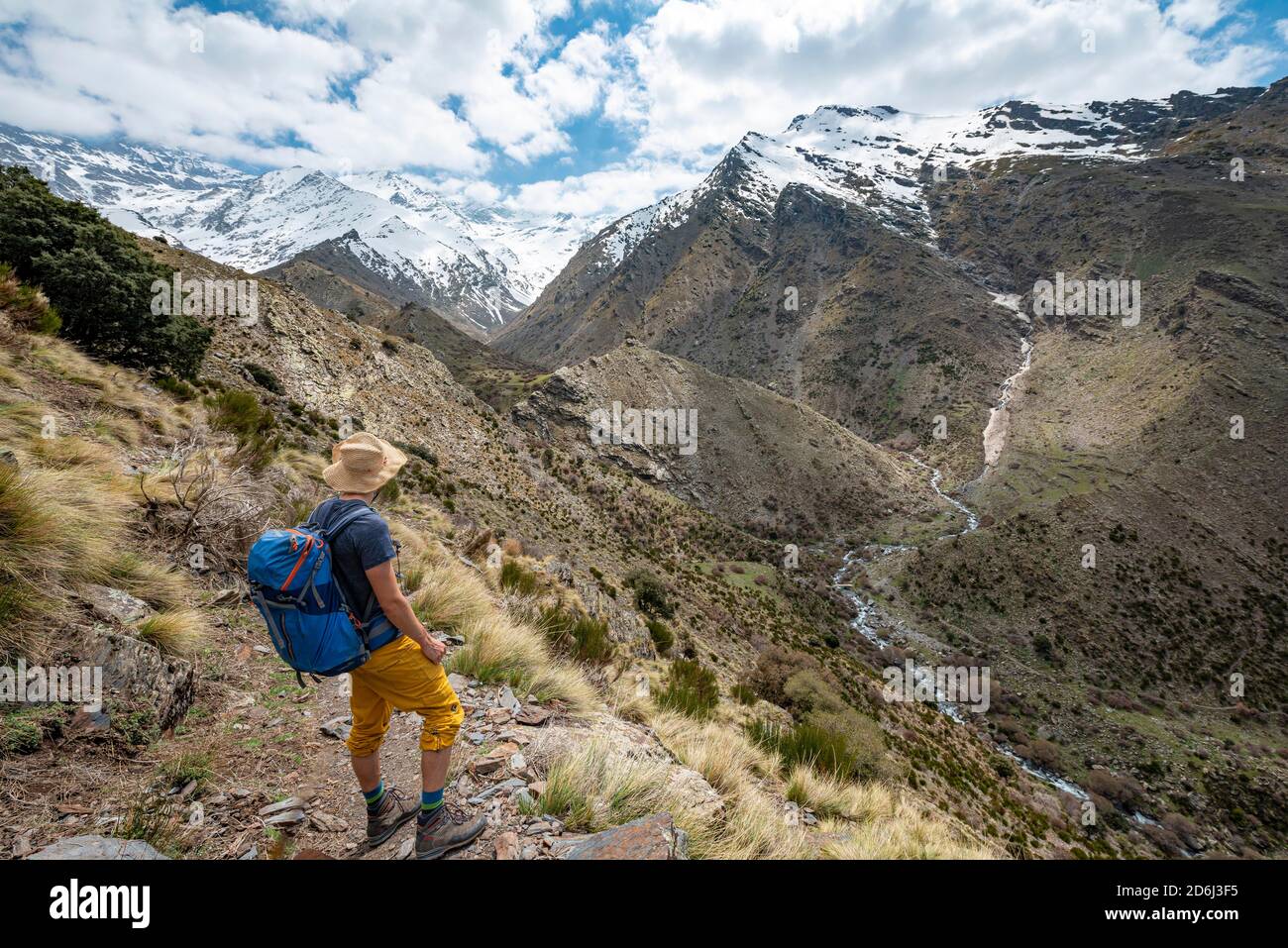 Randonneur sur un sentier de randonnée, sentier de randonnée Vereda de la Estrella, derrière la Sierra Nevada avec les sommets de Mulhacen et Pico Alcazaba, montagnes enneigées Banque D'Images