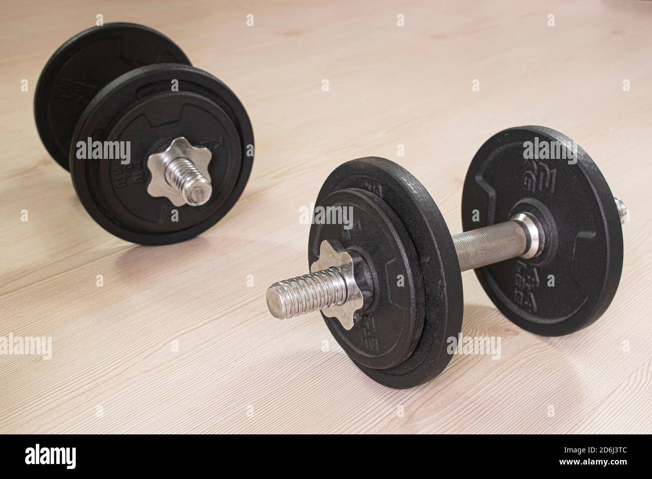 Haltères sur parquet. Photo de concept sportif à la maison Banque D'Images