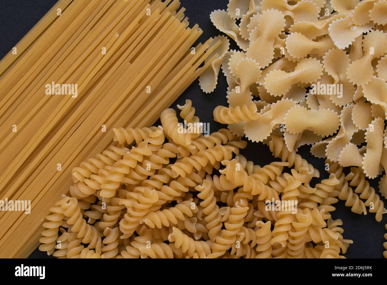 Pâtes italiennes sur fond noir. Farfalle, fusilli et spaghetti. Banque D'Images