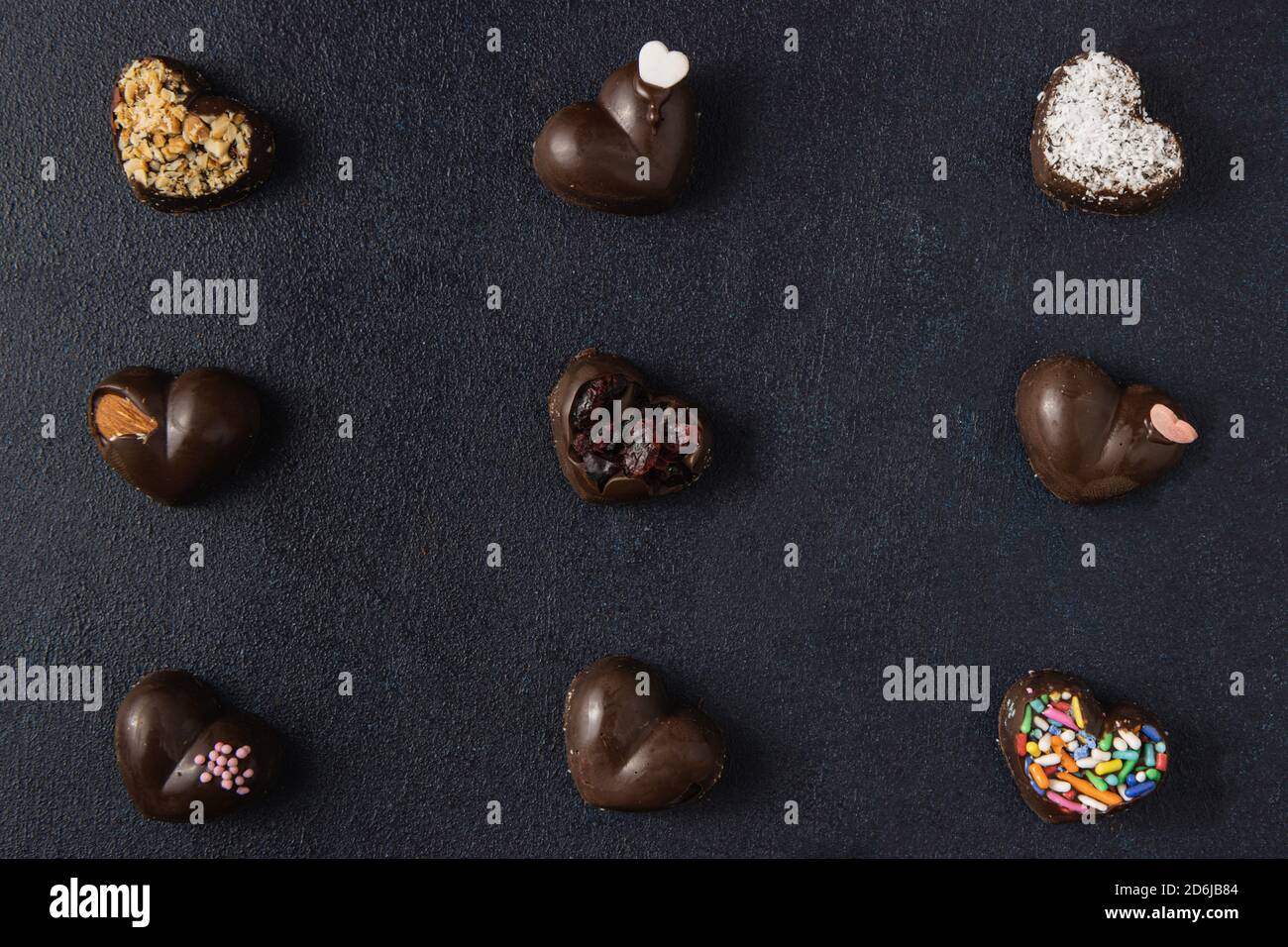 Pralines au chocolat isolées sur fond sombre. Vue de dessus, plan d'appartement. Banque D'Images