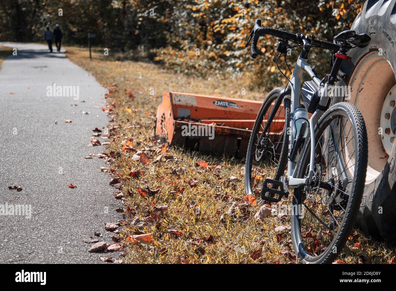 Une moto de gravier penchée contre un tracteur le long d'une voie verte chemin à l'automne Banque D'Images