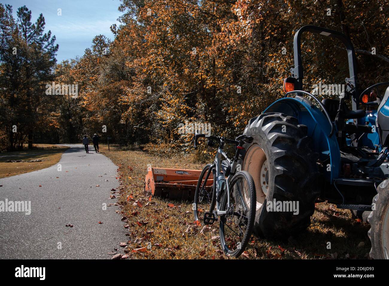 Une moto de gravier penchée contre un tracteur le long d'une voie verte chemin à l'automne Banque D'Images
