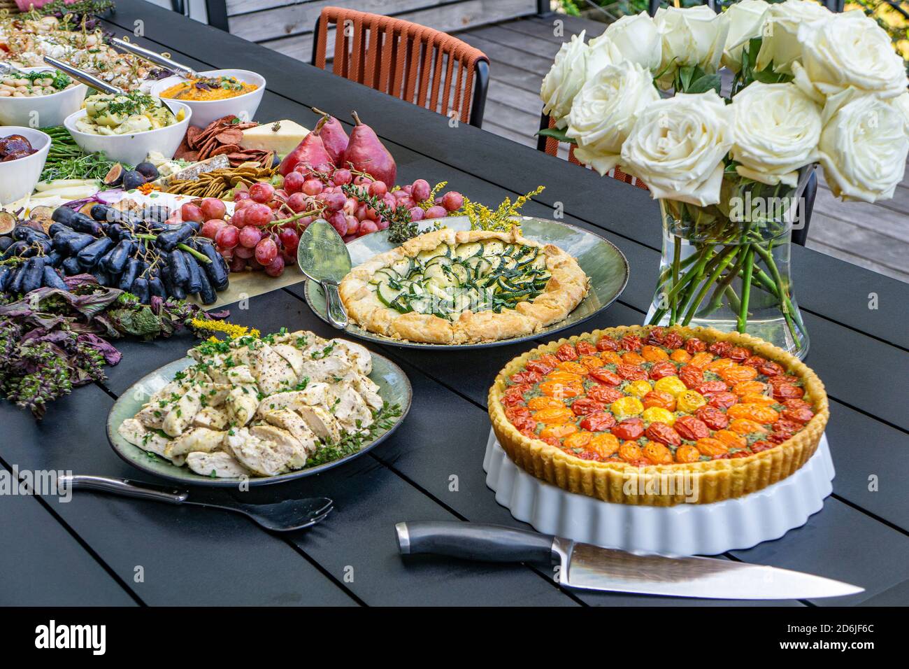 Planche à pâturage avec charcuterie, tartes, fruits et légumes sur table en extérieur Banque D'Images