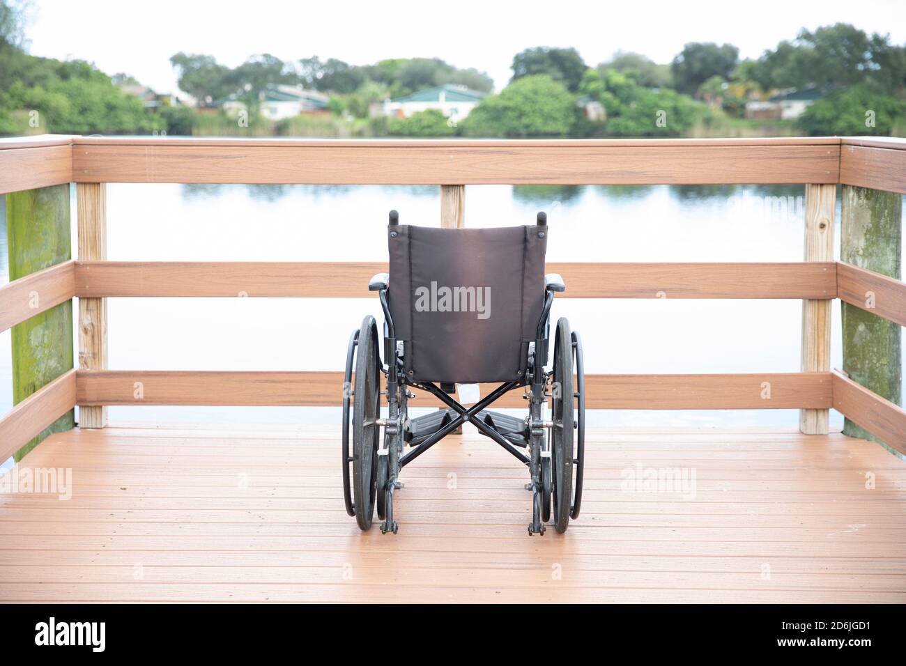 fauteuil roulant sur le pont au bord d'un lac Banque D'Images
