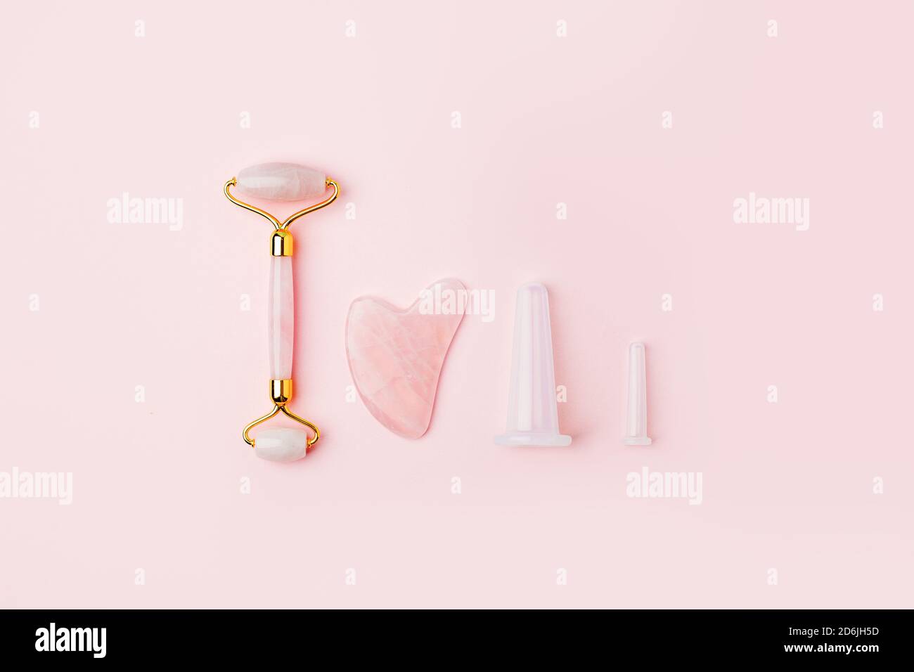 Rouleau de quartz de massage, pierre, outils pour le visage de la néphrite naturelle rose. Concept de massage et de relaxation du visage pour les soins de la peau. Outils de massage Gua Sha. Un Banque D'Images