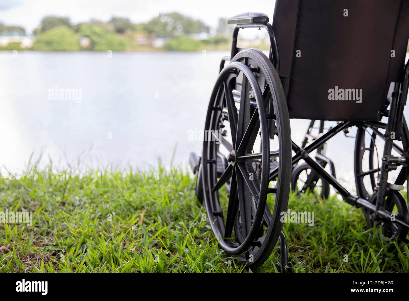 fauteuil roulant dans un parc en face d'un lac Banque D'Images