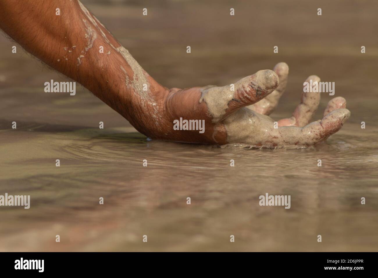 Gros plan de la main d'un homme sur le sable Banque D'Images