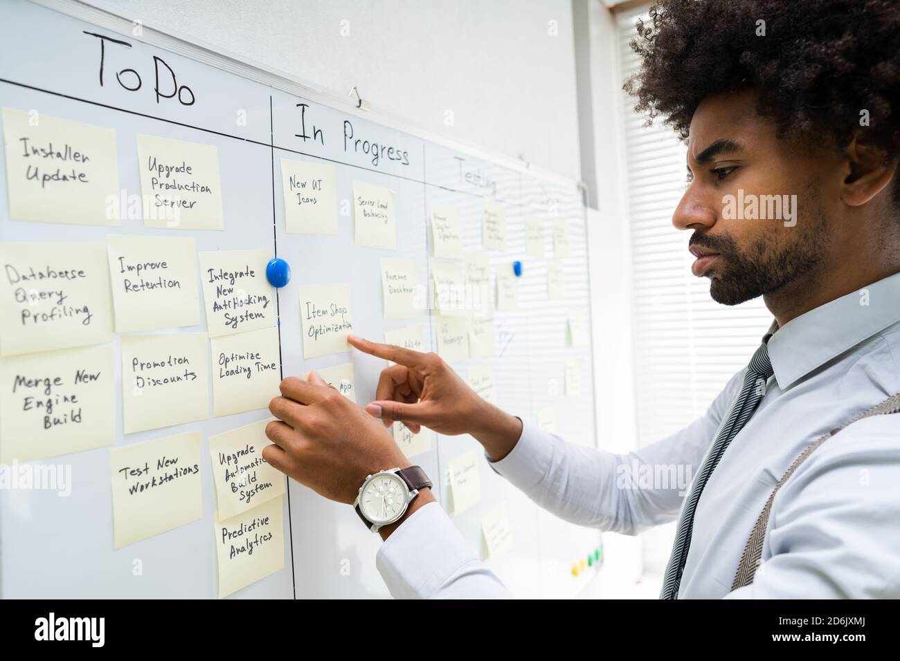 Homme d'affaires afro-américain travaillant sur Whiteboard Wall Banque D'Images