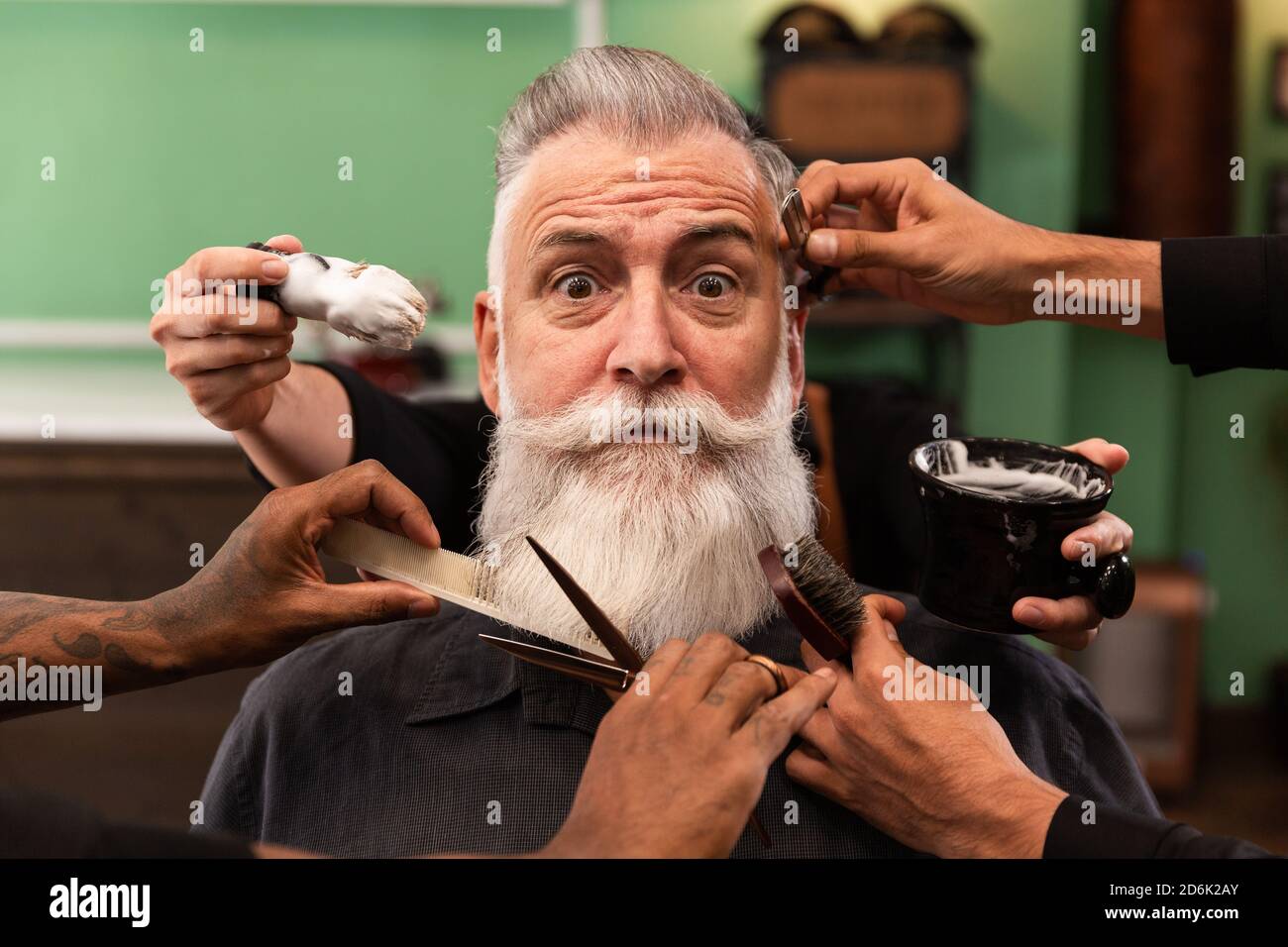 homme mature avec barbe blanche regardant l'appareil photo dans le salon de  coiffure avec les mains de barbier avec instruments de coupe et de rasage,  brosse, ciseaux, peigne, rasoir. hanche Photo Stock -