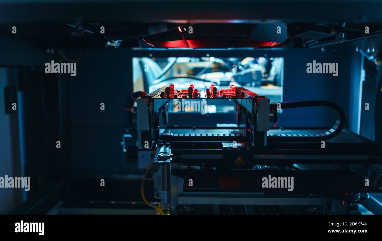 L'équipement industriel robotique automatisé teste la carte de circuit imprimé électronique et la rejette avec la technologie de lumière rouge et laser après l'assemblage. Banque D'Images
