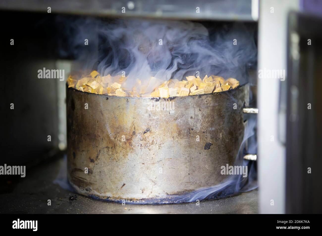 Pot en métal avec sciure et fumée dans un four industriel pour fumer le  poisson Photo Stock - Alamy