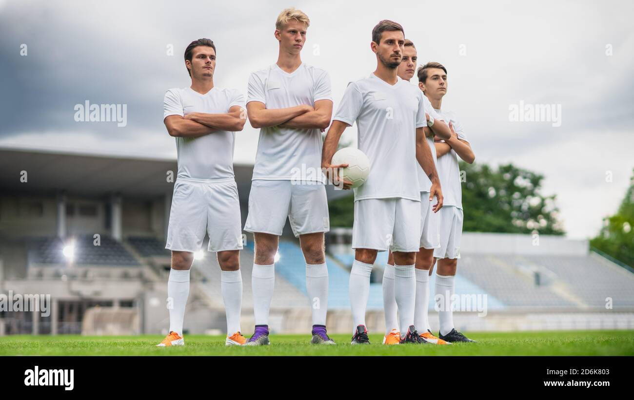 Équipe de joueurs de football professionnels posant pour une photo de groupe debout sur un terrain de football. Banque D'Images