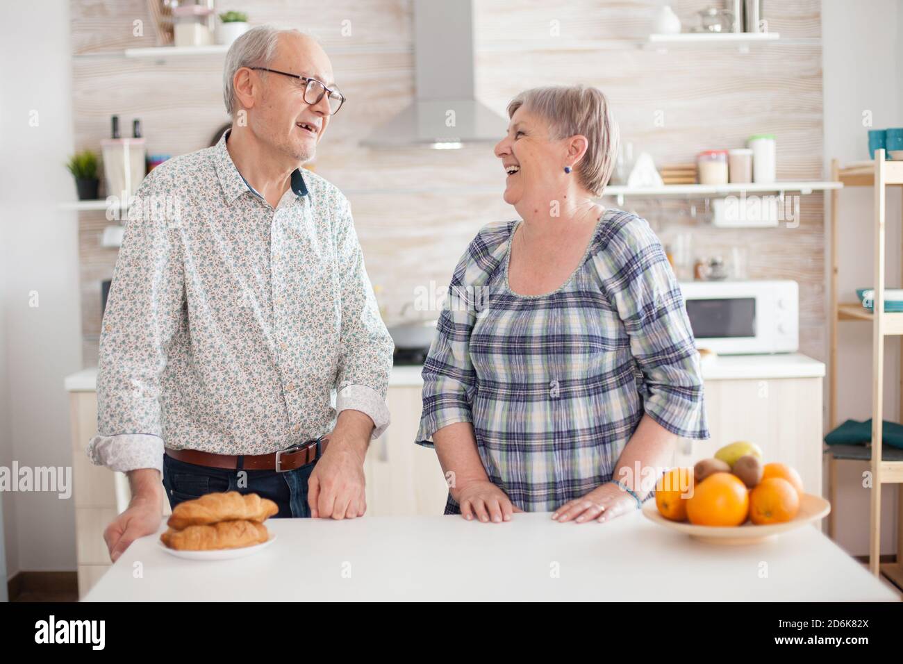 Portrait d'un couple senior dans la cuisine souriant l'un à l'autre et regardant l'appareil photo. Femme et mari joyeux. Banque D'Images