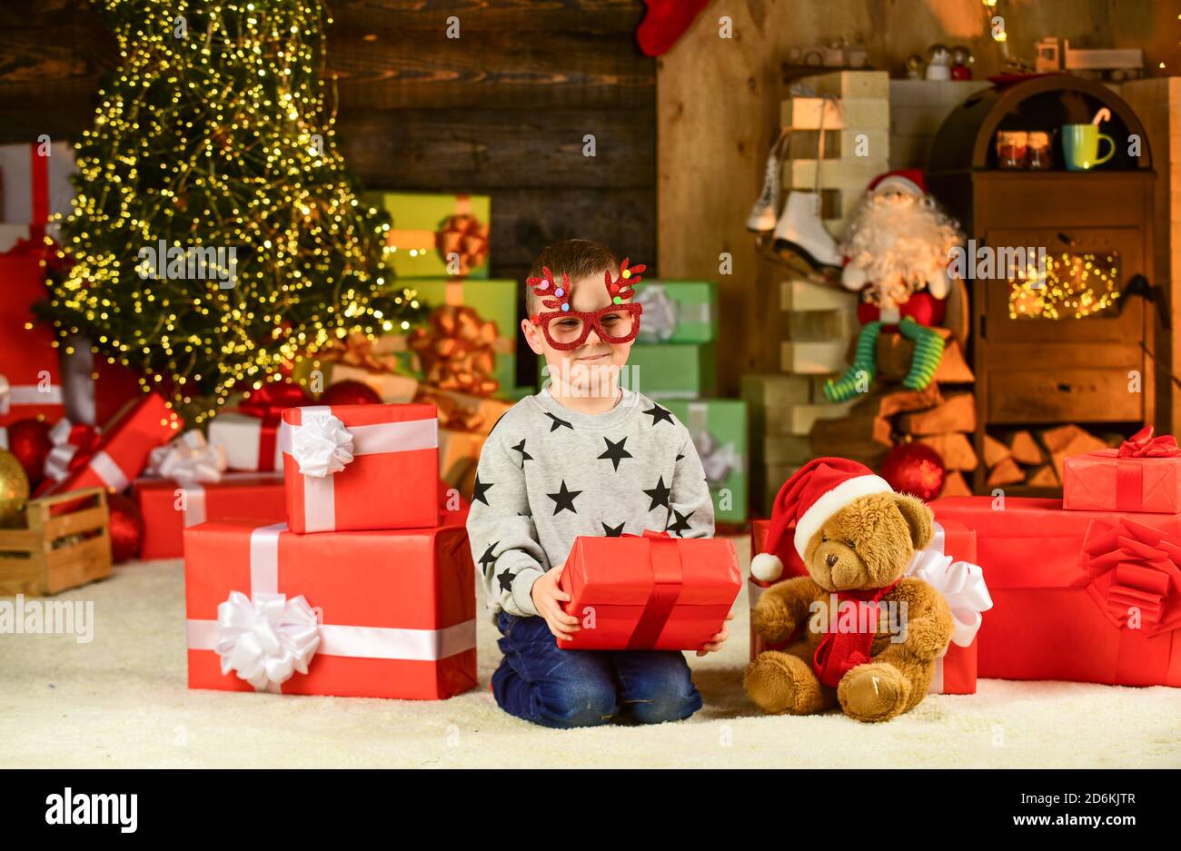 Ouverture de son cadeau de Noël. lunettes joyeux noël. Happy pour enfants. Son  fils est prêt à célébrer les vacances d'hiver. Petit garçon avec un cadeau  de père noël. Garde d'enfants boule