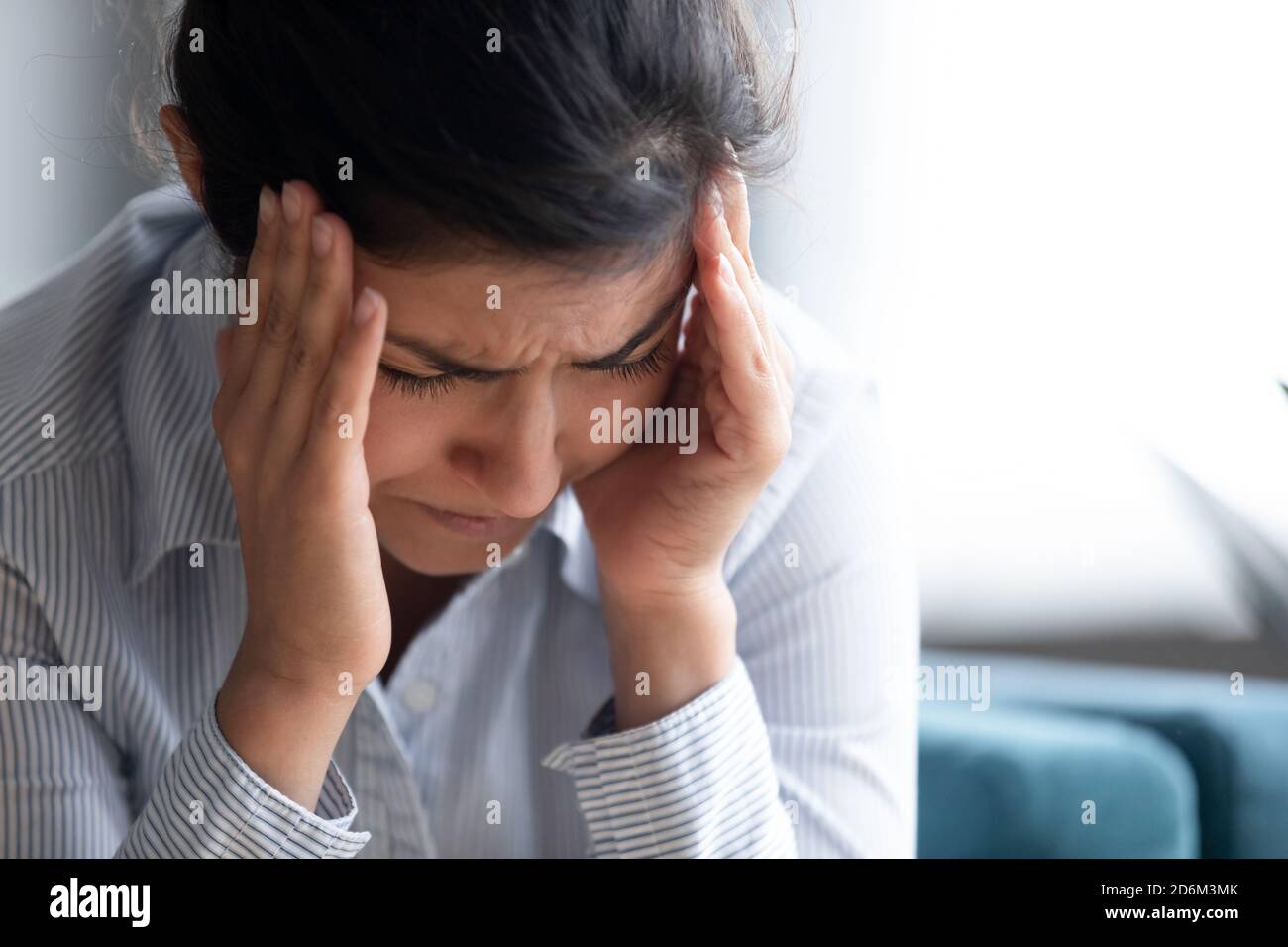 Les temples de contact de fille indienne stressés réduisent l'image de gros plan de mal de tête insupportable Banque D'Images