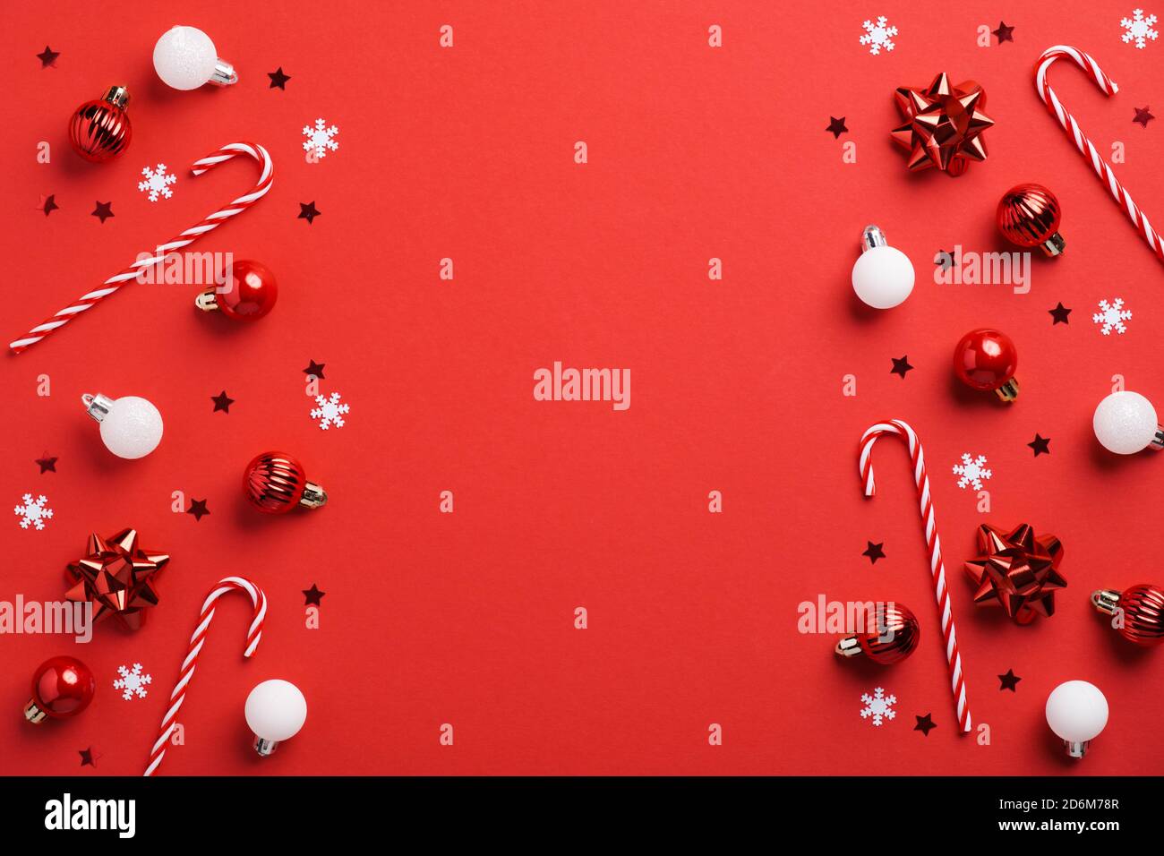 Fond de Noël rouge avec décoration en boules rouges et blanches, Cannes en sucre et confetti. Modèle de carte postale Noël, maquette de bannière. Banque D'Images Fond de Noël rouge avec décoration en boules rouges et blanches, Cannes en sucre et confetti. Modèle de carte postale Noël, maquette de bannière. Banque D'Images