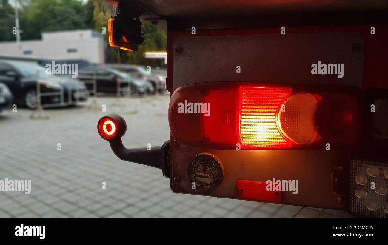 Gros plan du feu de gabarit arrière rond rouge d'un chariot. Feu arrière pour un chariot. L'arrière-plan est flou. Le concept de la sécurité sur la route Banque D'Images