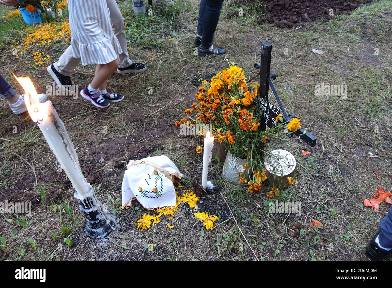 Les familles décorent les tombes de Patzcuaro, au Mexique, au cours de la journée des morts, avec des marigolds traditionnels, ainsi que des aliments et d'autres favoris de leurs proches. Banque D'Images