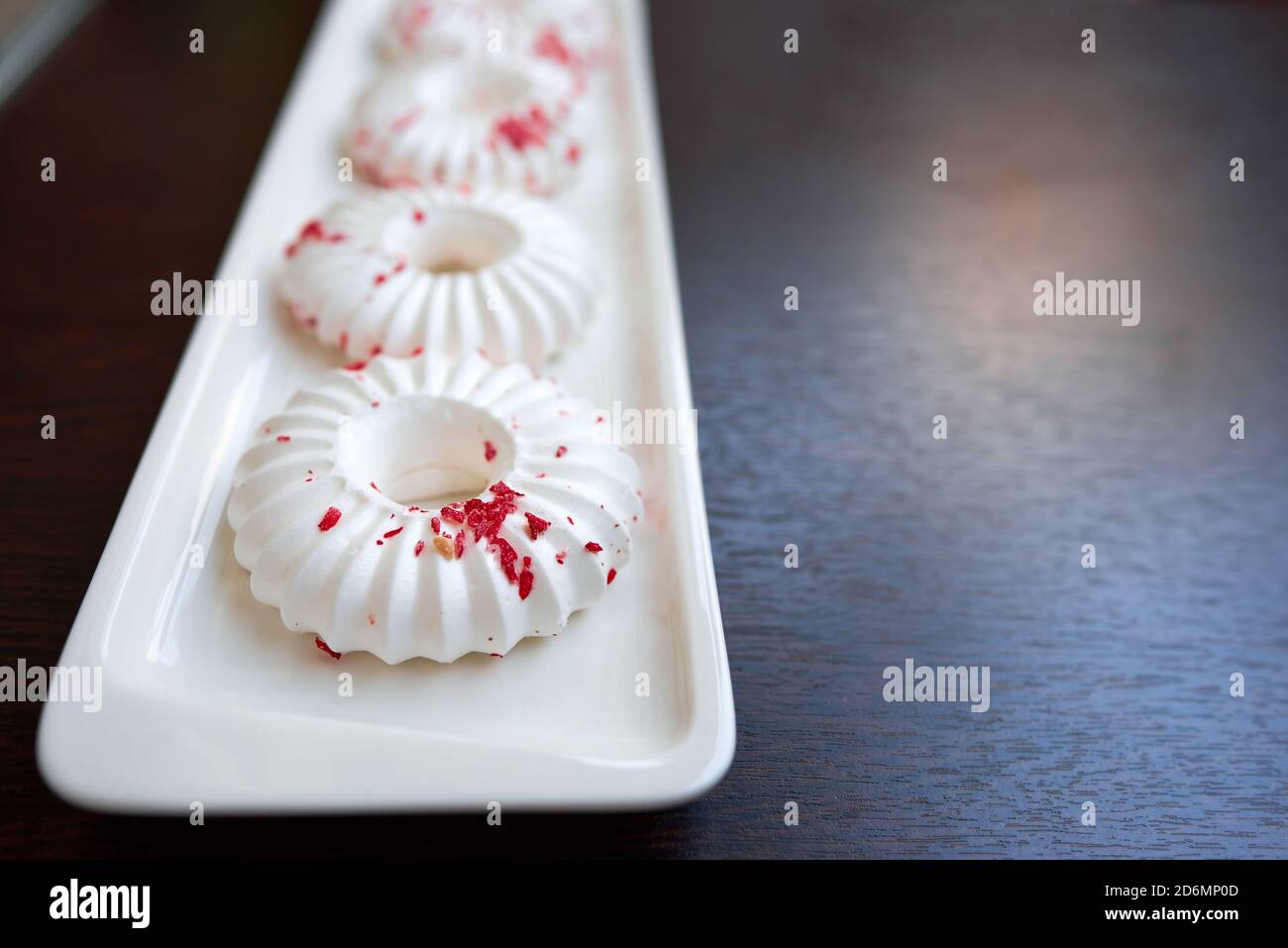 Gâteaux blancs à la meringue avec chapelure rouge. Gros plan. Mise au point sélective Banque D'Images