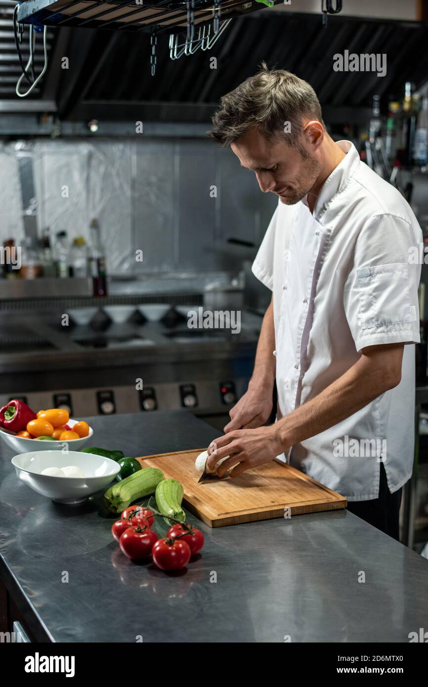 Jeune chef professionnel de restaurant moderne en coupe uniforme blanche oignon Banque D'Images