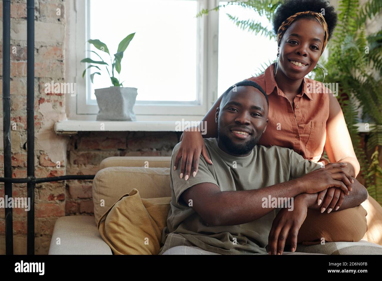 Joyeux jeune couple africain en vêtements décontractés vous regardant avec sourires crasseux Banque D'Images