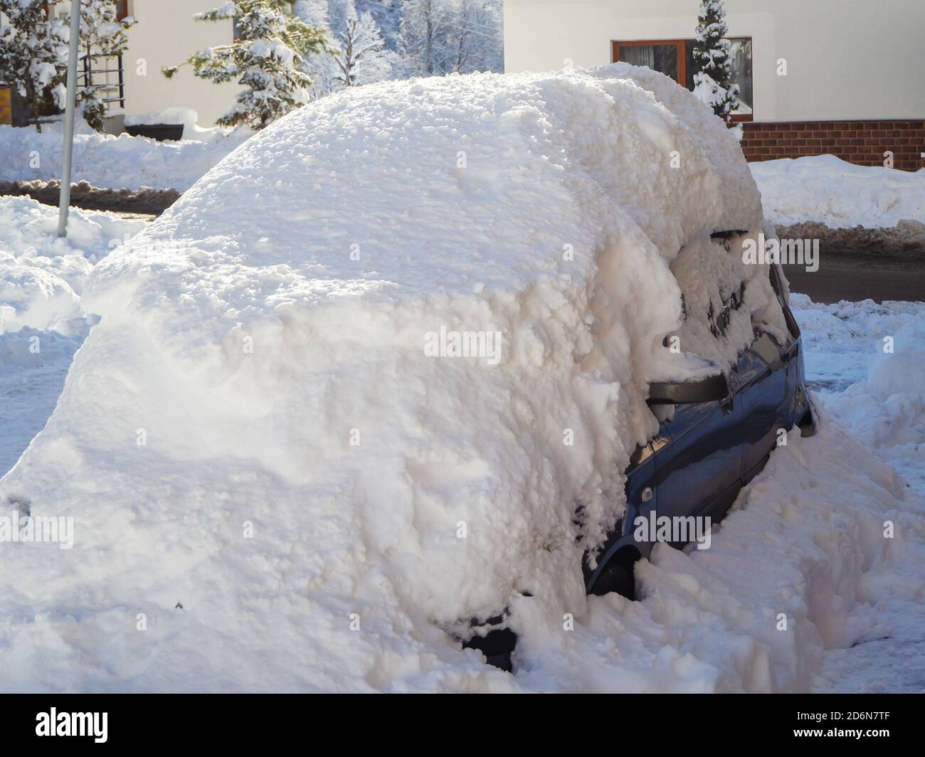 Une voiture jonchée d'une grande couche de neige dans la rue Photo Stock -  Alamy