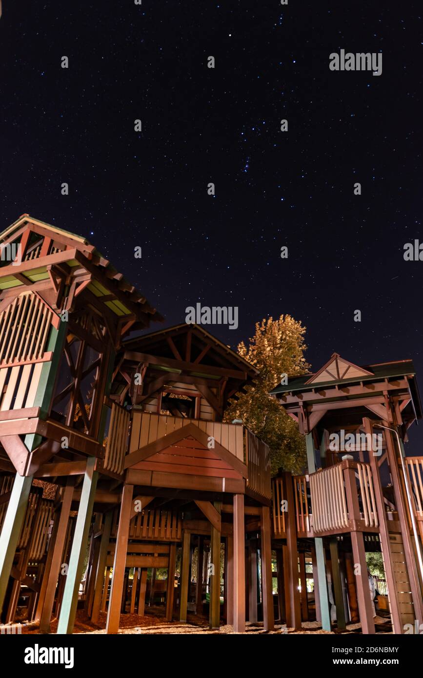 Grande structure d'escalade illuminée contre les étoiles de nuit dans le ciel dans le parc public de la ville. Banque D'Images