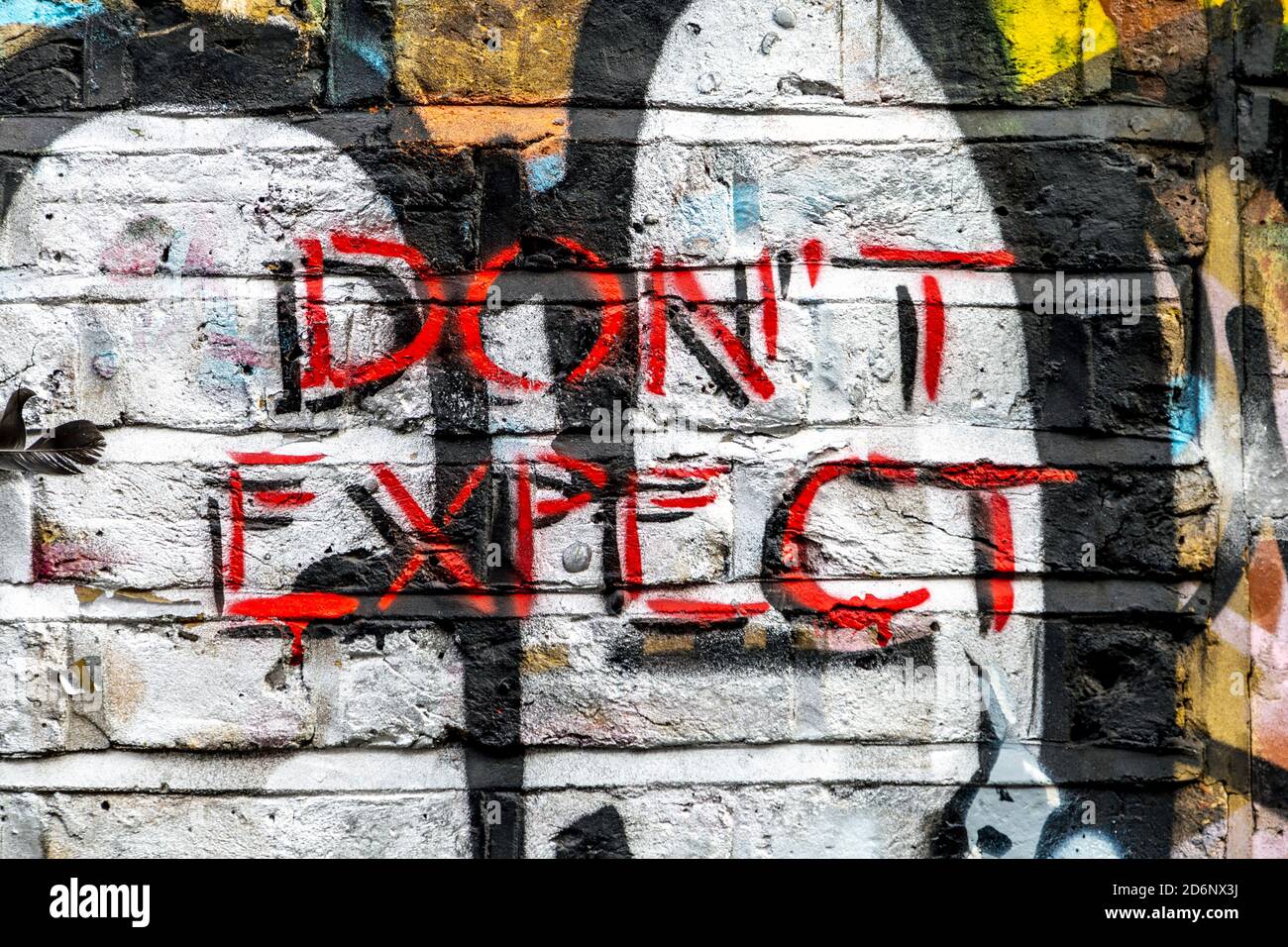 « ne vous attendez pas » peint sur un mur à Brick Lane, est de Londres, Royaume-Uni Banque D'Images