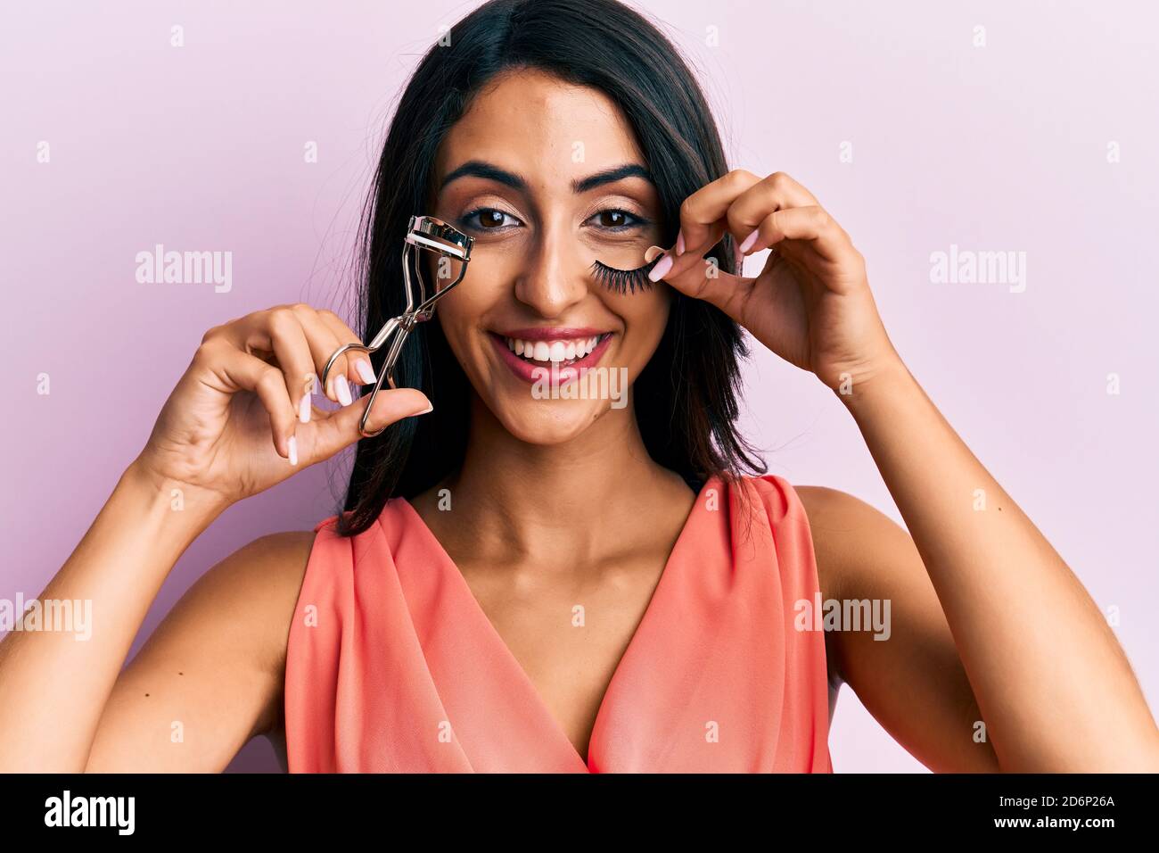 Belle femme hispanique tenant le fard à paupières et faux cils souriant et  riant fort parce que drôle de blague folle Photo Stock - Alamy