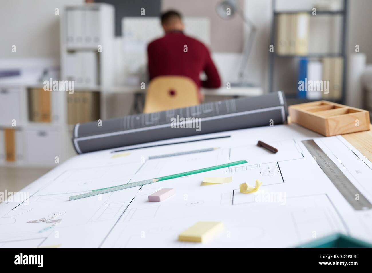 Image d'arrière-plan du poste de travail des architectes avec des plans et des outils sur la table de mise en plan au premier plan, espace de copie Banque D'Images
