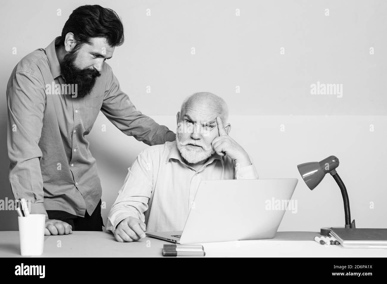 Deux employés de bureau travaillant à l'écran d'un ordinateur portable. Employés de bureau. Deux collègues d'affaires se rencontrent dans un intérieur de bureau moderne et coloré. Banque D'Images