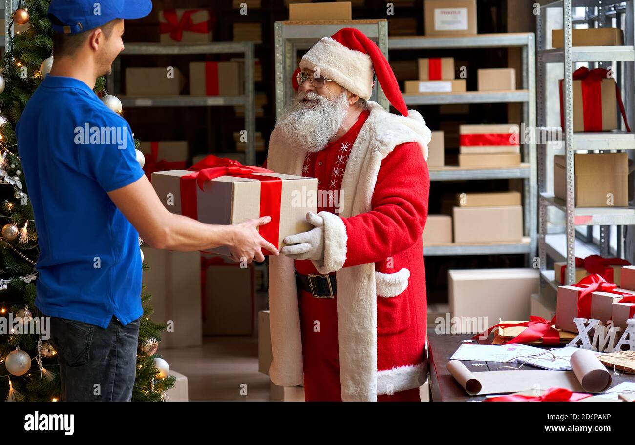 Le Père Noël heureux donnant boîte cadeau colis au coursier, livraison  rapide de noël Photo Stock - Alamy