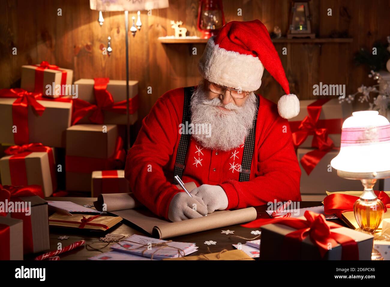 Joyeux Père Noël travaillant la veille de Noël assis à la table de la  maison Photo Stock - Alamy