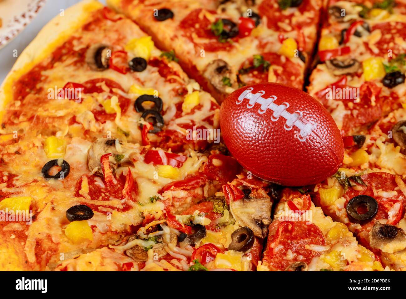 Pizza suprême pepperoni avec ballon de football pour la fête de football  américaine Photo Stock - Alamy