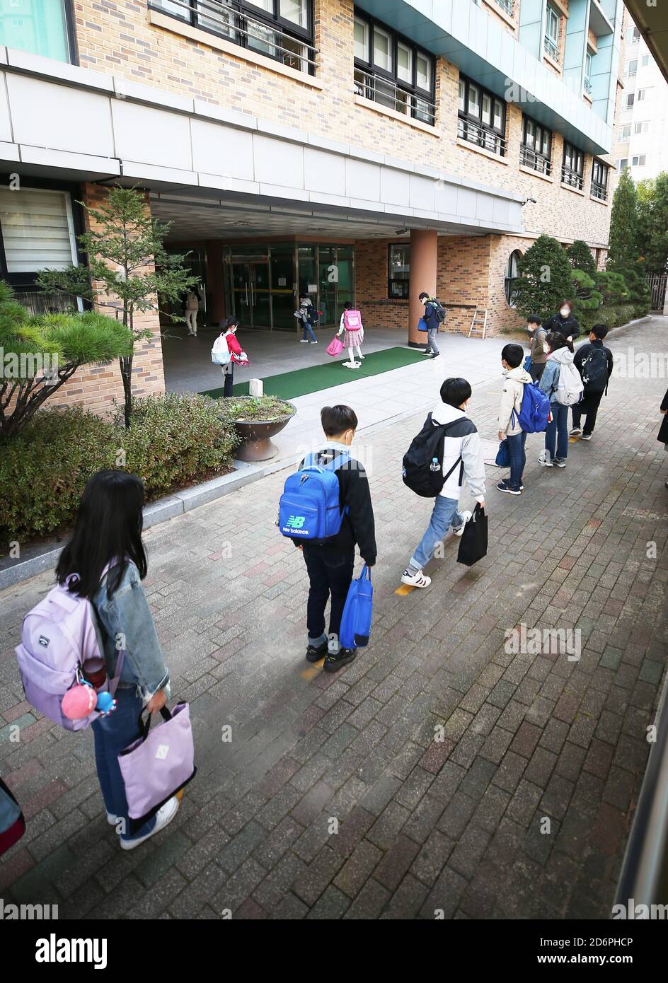 19 octobre 2020. Augmentation de la fréquentation scolaire des élèves attendez en ligne pour entrer dans une école primaire à Suwon, au sud de Séoul, le 19 octobre 2020, alors que le ministère de l'éducation a augmenté le plafond de fréquentation à deux tiers pour toutes les écoles, conformément à la décision du gouvernement de relâcher les directives de distanciation sociale à l'échelle nationale en raison d'un ralentissement des épidémies de coronavirus. Crédit : Yonhap/Newcom/Alay Live News Banque D'Images