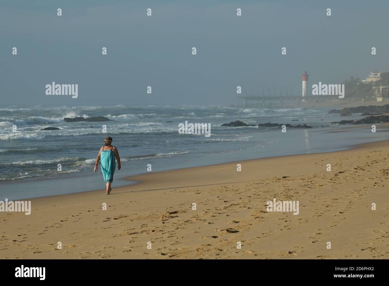 Paysage, femme adulte adulte unique mûr marchant sur la belle plage, Umhlanga Rocks front de mer, Durban, Afrique du Sud, destination de vacances en bord de mer, côte Banque D'Images