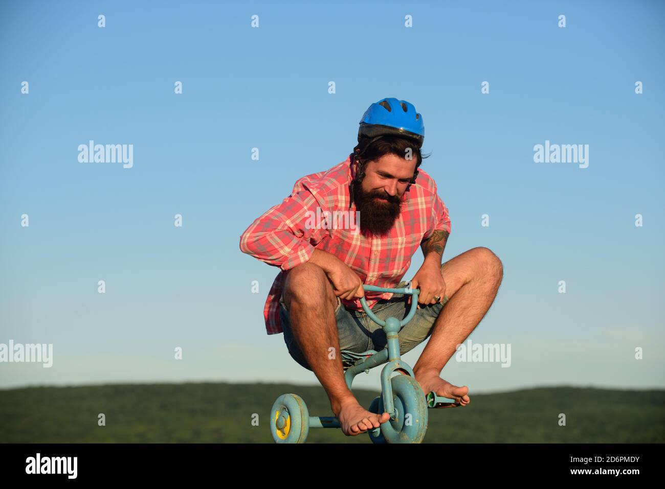 Drôle d'homme sur un vélo pour enfants. Vélo nerdy. Banque D'Images