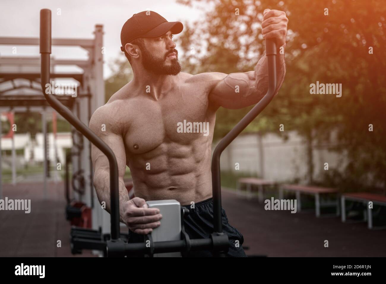 beau jeune athlète fort barbu homme en casquette debout exercice physique équipement de sport de rue Banque D'Images