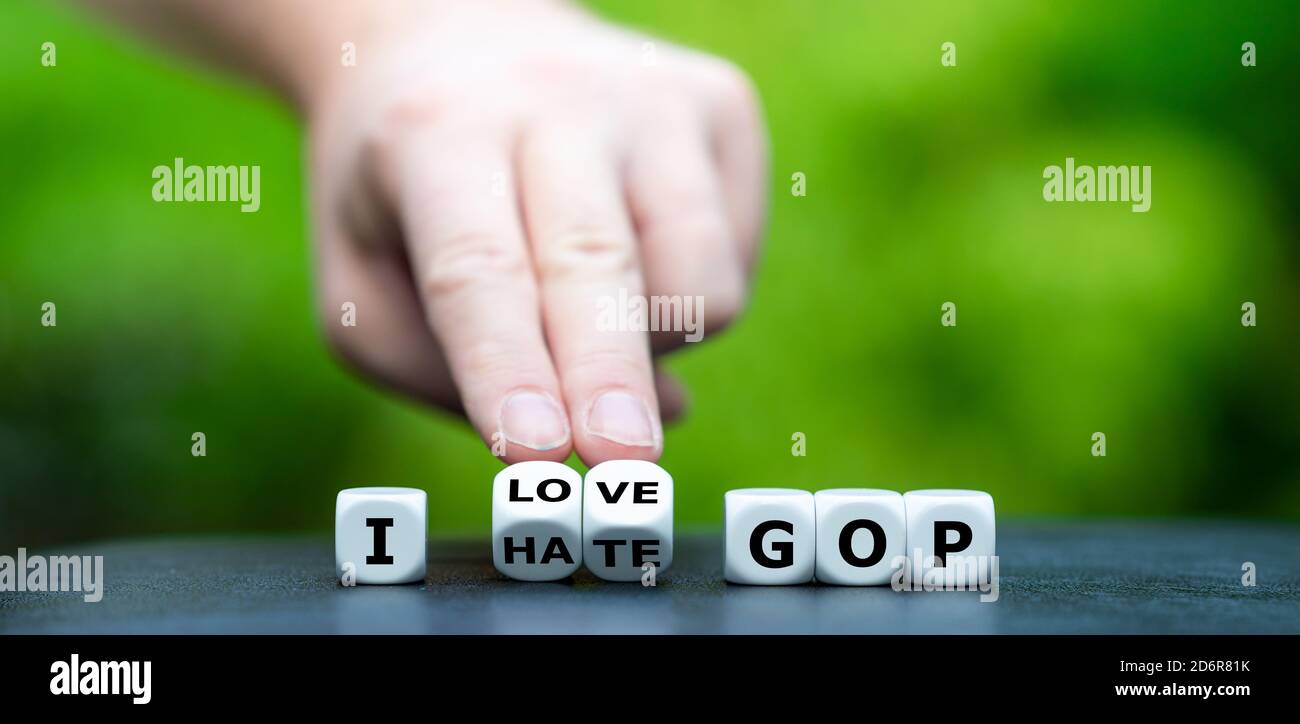 La main tourne les dés et change l'expression 'I Hate GOP' (grand vieux parti) à 'I Love GOP'. Banque D'Images