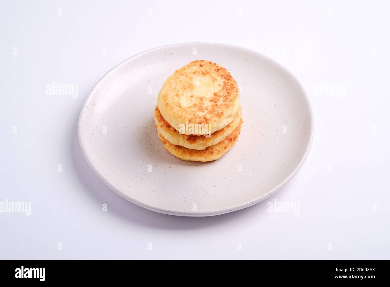 Beignets de fromage cottage. Dessert petit déjeuner dans l'assiette sur fond blanc, vue en angle Banque D'Images