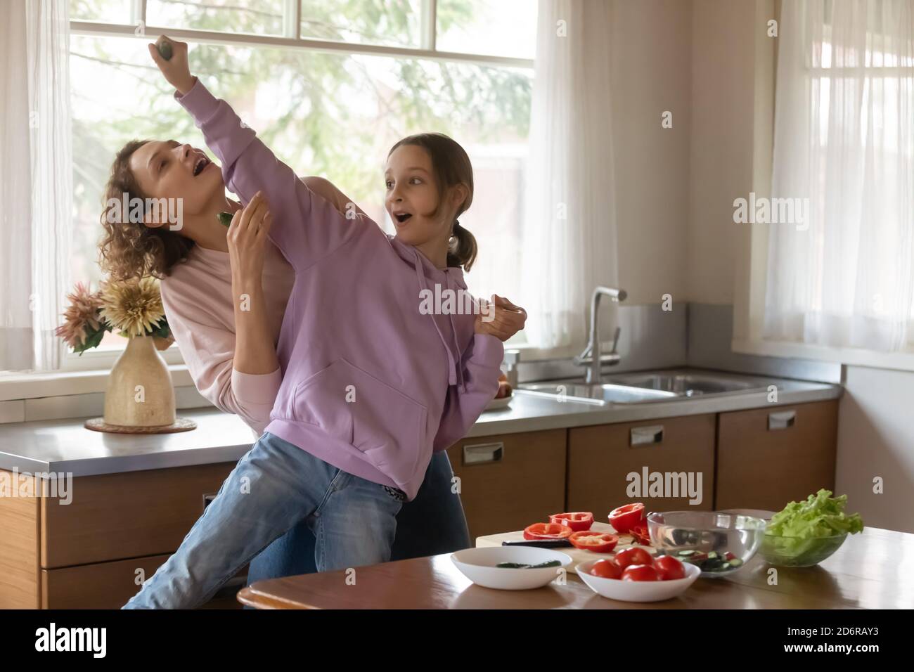 Maman et fille de l'adolescence surjoyées ont plaisir à cuisiner Banque D'Images