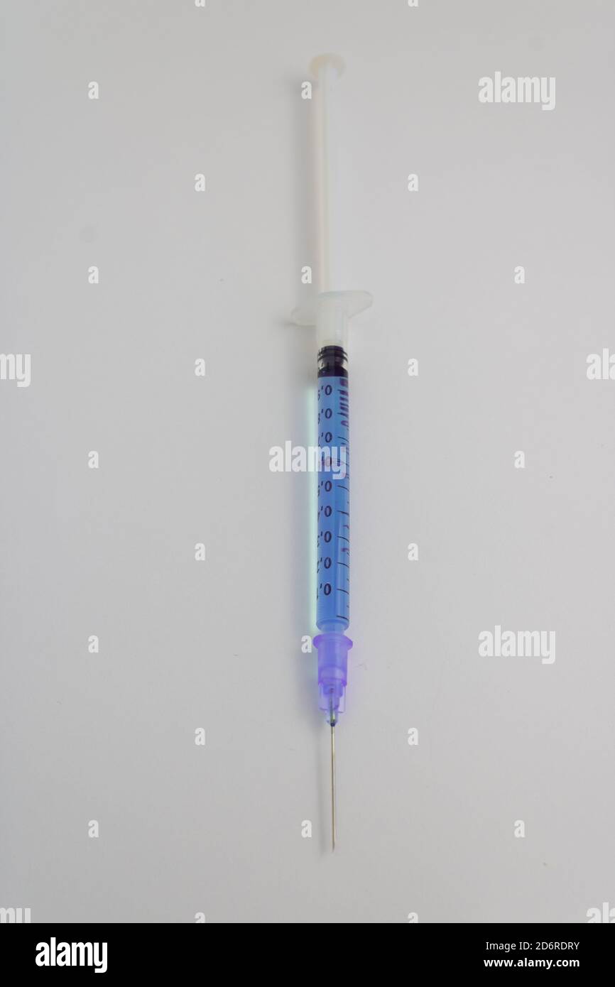 seringue à aiguille avec médicament bleu isolé sur fond blanc Banque D'Images